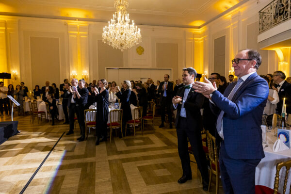 Im Strauss-Saal im Kursalon stehen viele Menschen uns applaudieren in Richtung der Bühne.